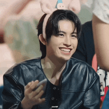 a young man wearing a headband with pig ears is smiling for the camera