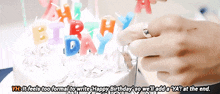 a person with a ring on their finger lighting a birthday cake