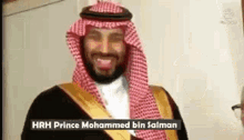 prince mohammed bin salman is smiling for the camera while wearing a keffiyeh and a robe .