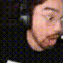 a close up of a man 's face wearing headphones and glasses .