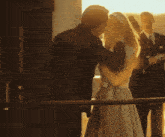 a man and a woman are kissing in front of a crowd