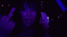 a man wearing a dani t-shirt stands next to a woman in a dark room