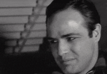 a close up of a man 's face in a black and white photo with a serious look on his face .