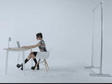a woman sitting at a desk with a laptop on it
