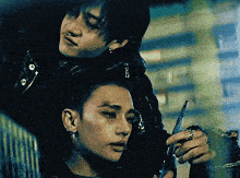 two men are standing next to each other and one is holding a gun .