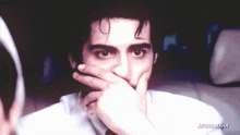 a close up of a person covering their mouth with their hand and the words miyasaliha on the bottom
