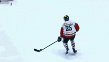 a hockey player with the number 25 on his jersey tries to get the puck