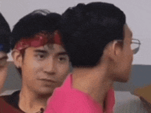 a group of young men are standing next to each other and one of them is wearing a bandana .