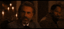 a man with long hair and a beard sits next to another man with a beard