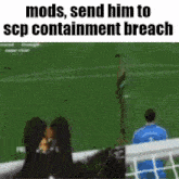 a man in a blue shirt is watching a soccer game on a soccer field .