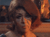 a close up of a woman 's face with a painting behind her