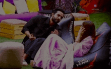 a man sits next to a woman on a bean bag chair that says too yumm