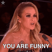 a woman is sitting in front of a microphone and says " you are funny "