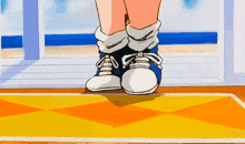 a person wearing a pair of blue and white sneakers is standing on a yellow mat .