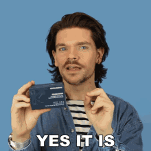 a man in a denim shirt is holding a box of kevin murphy product