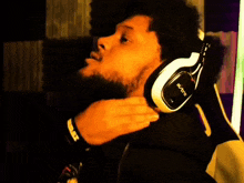 a man wearing a pair of black and white headphones that say xbox