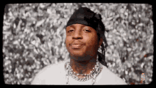 a close up of a man wearing a bandana and a chain .