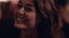 a woman is smiling and looking at a man in a dark room