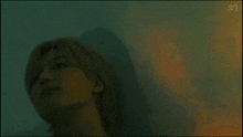 a blurry picture of a person 's face with a shadow on the wall behind them