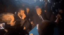 a blurry picture of a crowd of people in suits
