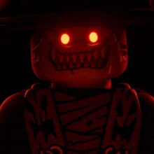 a close up of a lego character with red eyes and teeth
