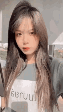 a girl with long hair is wearing a t-shirt that says ' surui ' on it