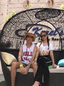 a man wearing a bulls jersey sits next to a girl