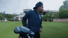 a man carrying a bag of golf clubs that says eagle