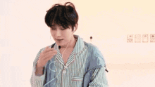 a young man in a blue shirt is talking in korean