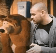 a man is standing next to a stuffed animal that looks like a dog .