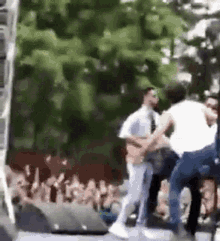 a group of people are dancing on a stage in front of a crowd of people .