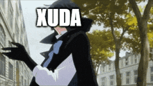 a man in a black coat and gloves is standing in front of a building with the word xuda written on it .