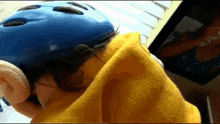 a person wearing a blue helmet and a yellow sweater