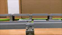 a toy train is going over a bridge on a track .
