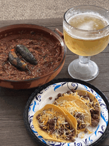a plate of tacos sits next to a bowl of chili