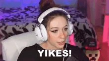 a woman wearing headphones is sitting in a chair and making a funny face .