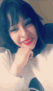 a girl with a nose ring and red lipstick smiles for the camera
