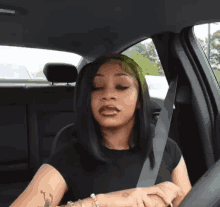 a woman is sitting in the back seat of a car with a seat belt on .