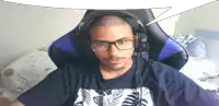 a man wearing glasses and headphones sits in a chair