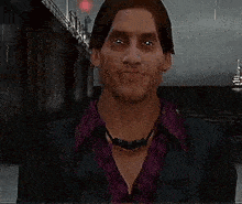 a man wearing a purple shirt and a black jacket is standing in front of a body of water .