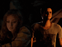 a man and a woman standing next to each other in the dark