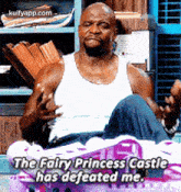 a man in a white tank top is sitting on a bed and says `` the fairy princess castle has defeated me ''