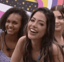 a group of women are smiling and laughing while standing next to each other .