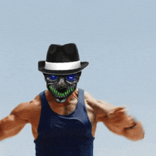 a man wearing a hat and a mask with green teeth is flexing his muscles
