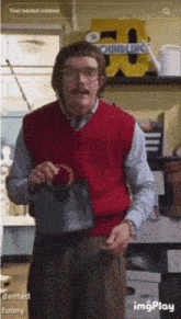 a man in a red vest is holding a black purse in front of a sign that says foundling