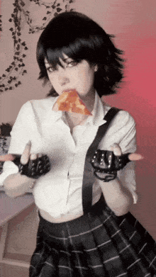 a girl in a school uniform is eating a piece of pizza