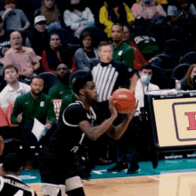 a man holding a basketball in front of a sign that says i on it