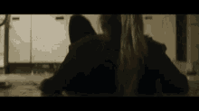 a man and a woman are sitting back to back in a dark room