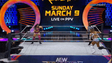 two women in a wrestling ring with a sign that says sunday march 9