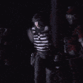 a man in a black and white striped shirt is dancing on stage